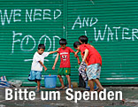 Auf einer Wand steht "We need Food and Water"