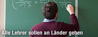 Ein Lehrer schreibt an eine Tafel