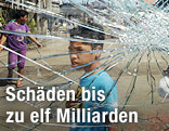 Menschen blicken durch zerbrochene Glasscheibe