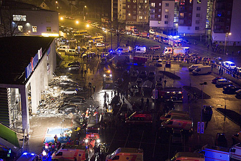 Einsatzfahrzeuge vor eingestürzem Supermarkt