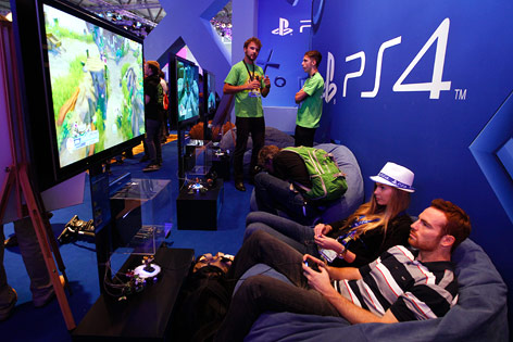 © Reuters/Ina Fassbender Besucher der Gamescom 2013 in Köln spielen auf einer PS4