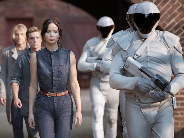 © Studiocanal/Murray Close Katniss Everdeen (Jennifer Lawrence, vorne), Peeta Mellark (Josh Hutsherson, Mitte), Haymitch Abernathy (Woody Harrelson, hinten) flankiert von Friedenswächtern