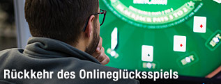Mann sitzt vor Bildschirm und spielt Blackjack