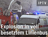 Rettungswagen und Feuerwehr beim ausgebrannten Buswrack