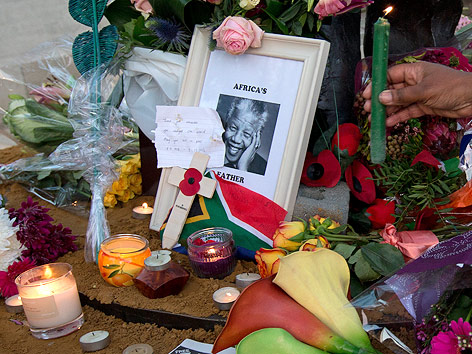 © APA/AP/Alastair Grant Kerzen und Blumen rund um ein Bild von Nelson Mandela