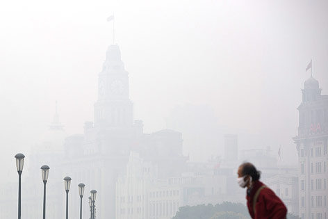 © Reuters/Aly Song Ein Mann steht vor der durch Smog komplett verdeckten Skyline von Schanghai
