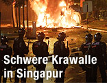 Polizisten stehen vor einem Feuer