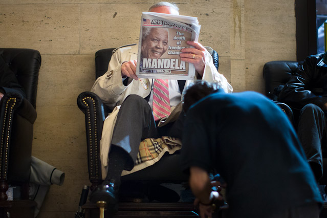 © AP/John Minchillo Mann beim Zeitungslesen mit Todesnachricht Mandelas