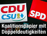 Logos der Parteien CDU/CSU und SPD auf einem schwarzen Ordner