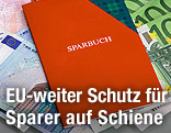 Sparbuch liegt auf Geldscheinen
