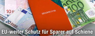 Sparbuch liegt auf Geldscheinen