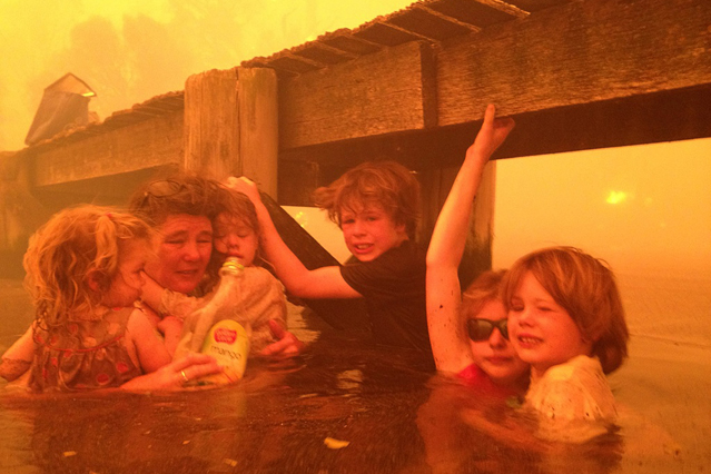 © AP Photo/Tim Holmes Familie auf der Flucht vor dem Feuer