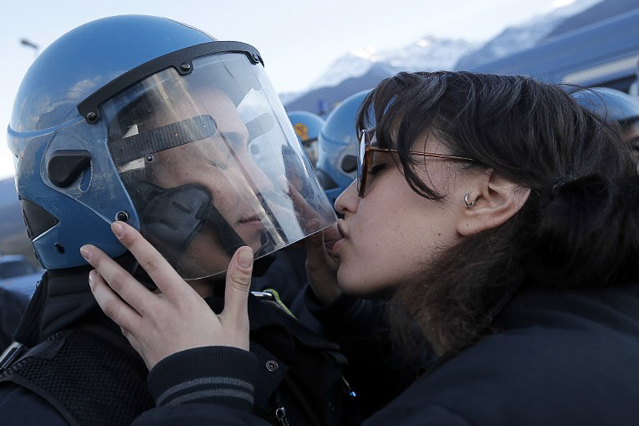 © AFP/Marco Bertorello Demostrantin küsst Polizisten
