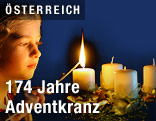 M&auml;dchen z&uuml;ndet Kerze auf einem Adventkranz an