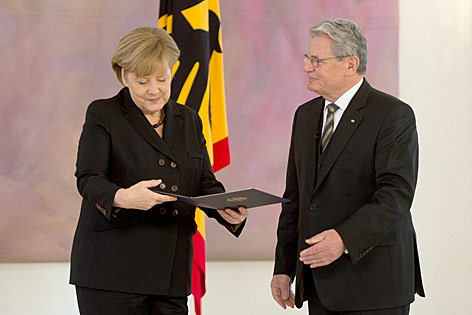 Deutschlands Bundespräsident Joachim Gauck überreicht die Ernennungsurkunde an die wiedergewählte Bundeskanzlerin Angela Merkel