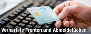 Mann hält E-Card in der Hand
