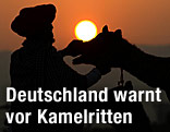 Mann und Kamel im Gegenlicht der Abendsonne