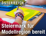 Schülerin hält Kugelschreiber in der Hand