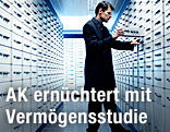 Mann steht vor offenem Bankschlie&szlig;fach