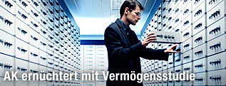 Mann steht vor offenem Bankschließfach