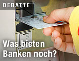 Mann behebt Geld am Bankomat