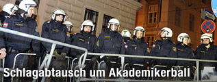 Polizisten hinter Absperrungen