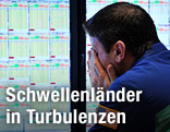 Aktienhändler sitzt vor einem Display