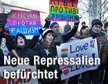 Demonstranten mit Schildern in Regenbogenfarben