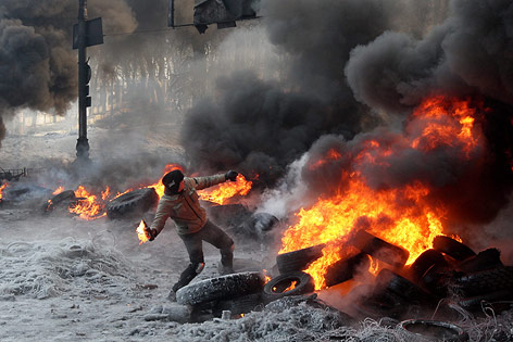 © APA/EPA/Zurab Kurtsikidze Demonstrant zwischen brennenden Reifen wirft Molotov-Cocktail
