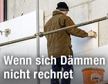 Arbeiter bringt Wärmedämmung an