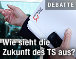 Mann hält Unterlagen des Teams Stronach in der Hand