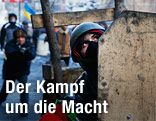 Regierungsgegner suchen hinter Holzplatten Schutz vor den Wasserwerfern