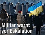Zivilisten stehen ukrainischen Polizisten gegenüber