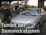 Mann schlägt mit Stock auf Auto