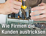 Ein Mann repariert mit einer Zange ein elektronisches Bauteil