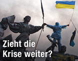 Demonstrant mit Fahne auf Statue