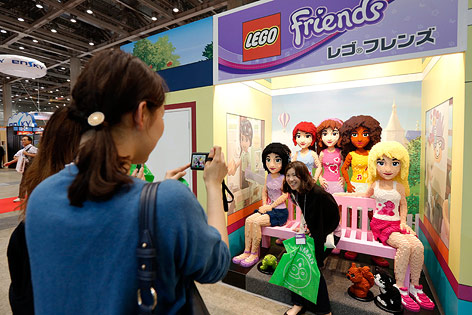 © APA/EPA/Kiyoshi Ota Mädchen posiert vor Lego Friends Figuren