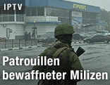 Bewaffnete Miliz patrouilliert vor dem Flughafen Simferopol