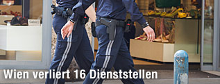 Zwei Polizisten gehen auf Gehsteig