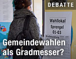 Eine Frau betritt ein Wahllokal