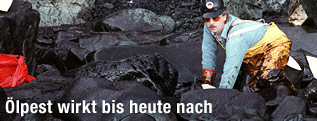 Helfer auf Knien bei den Reinigungsarbeiten nach der Havarie des Öltankers Exxon Valdez
