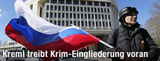 Mann mit russischer Fahne vor Parlament in Simferopol