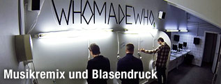Schriftzug "Who made who" auf einer Männertoilette