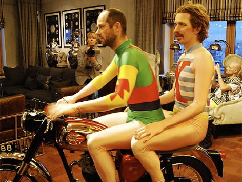 Jeppe Kjellberg und Bon Homme der Band Who Made Who sitzen auf einem Motorrad im Zimmer