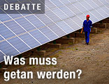 Arbeiter vor einem Solarpanel