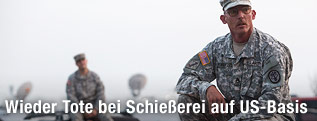 Staff Sgt. John Robertson steht auf der Motorhaube eines Autos