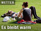 Zwei junge Frauen sonnen sich auf einer Wiese