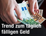 H&auml;nde mit Geldscheinen
