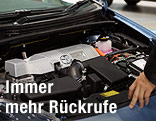 Mann betrachtet einen Motor bei geöffneter Motorhaube