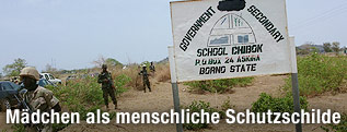 Soldaten und Schild einer Schule in Chibok, Nigeria